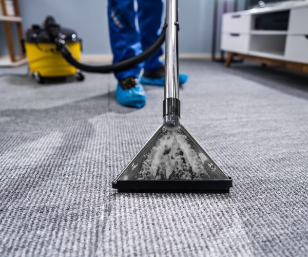 Photo Of Janitor Cleaning Carpet With Vacuum Cleaner